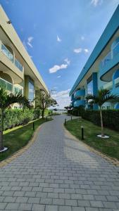 a brick walkway next to a building with palm trees at Golden Lake in Arraial do Cabo