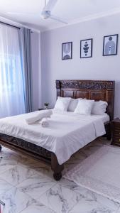 a bedroom with a large bed with white sheets at the cozy lookout in Malindi