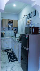 a kitchen with a refrigerator and a microwave at the cozy lookout in Malindi
