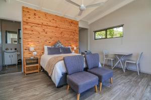Un dormitorio con una cama y dos sillas y una mesa. en Lagoon View Accommodation, en Knysna