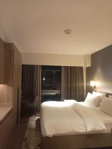 Ένα ή περισσότερα κρεβάτια σε δωμάτιο στο RBR Lux at Novotel Manila Hotel Residences Acqua