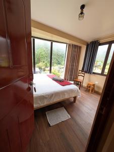 a bedroom with a bed and a large window at TUMI Villa Salkantay in Colcapampa