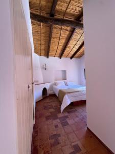 ein Schlafzimmer mit einem Bett und einer Holzdecke in der Unterkunft El Patio in Purmamarca