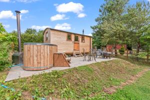 YarpoleにあるOff-Grid Glamping - Quiet, Starry Escapeの樽とパティオのある小さな家