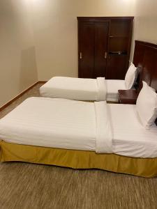 een paar bedden in een hotelkamer bij فندق روز بلازا in Abha