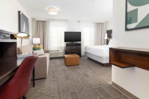 a hotel room with a bed and a tv at Staybridge Suites Chandler by IHG in Chandler