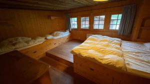 a bedroom with three beds in a wooden room at Ourson in Grimentz
