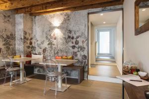 a kitchen with a table and chairs and a wall at Affittacamere CASA DOLCE CASA SAN DANIELE in San Daniele del Friuli
