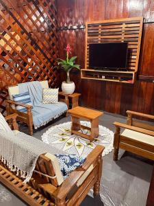 a living room with furniture and a flat screen tv at Casa de Praia Tribo de Judá in Bragança