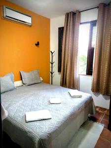 Un dormitorio con una cama con dos toallas encima. en Casa Mandacaru Pousada, en Caucaia