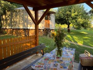 a table with a vase of flowers on a patio at Jurta na Souvrati 