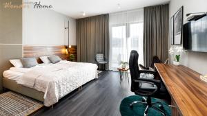 a bedroom with a bed and a desk with a chair at Wonder Hill - apartamenty hotelowe z dostępem do basenów i jacuzzi in Sosnówka