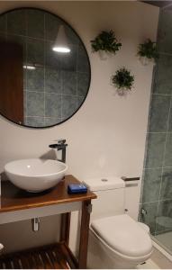 a bathroom with a sink and a toilet and a mirror at Manawa Kaona in Somondoco
