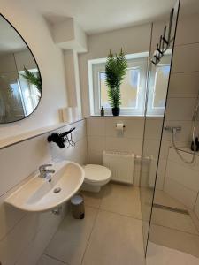 une salle de bain avec un lavabo, des toilettes et un miroir dans l'établissement Stilvolles Apartment,3SZ,Einzelbetten,Legoland,Ulmer Münster,bis6P, à Blaustein