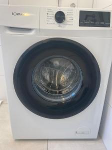 une machine à laver blanche avec sa porte ouverte dans l'établissement Stilvolles Apartment,3SZ,Einzelbetten,Legoland,Ulmer Münster,bis6P, à Blaustein