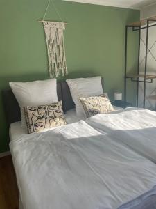 un letto grande con lenzuola e cuscini bianchi di Stilvolles Apartment,Familien und Gruppen,3SZ,Legoland,Ulmer Münster,bis6P a Blaustein