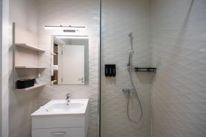 a white bathroom with a shower and a sink at Ivory Garden Retreat by Blvd 63B3 in Bucharest