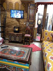 a living room with a couch and a tv on a wall at Dar Dahab in Fès +31 photos