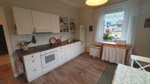 eine Küche mit weißen Schränken und einem Fenster in der Unterkunft Cozy 2-room apartment in Hohendorf + 11 Fotos