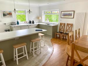 Una cocina con encimera, mesa y sillas. en Shore House, en Tarbet 13 fotos más