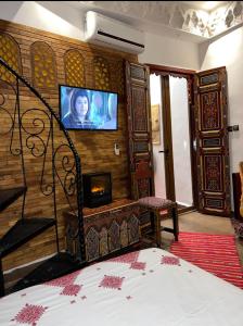 a bedroom with a bed and a tv on a wall at Dar Dahab in Fès