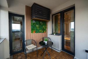 a small table and chairs in a room with a window at Ivory Garden Retreat by Blvd 63B3 in Bucharest