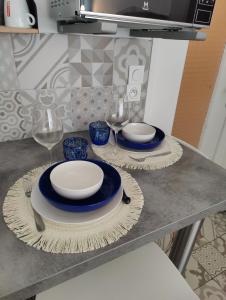 Una mesa con platos y copas de vino encima. en Carré d'Or - Studio lumineux à 5 minutes de la plage, en Niza