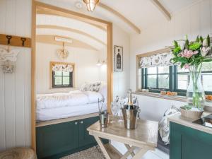 a bedroom with a bed and a table and a mirror at Poppie's Shepherd Hut - Uk50227 in Redmile