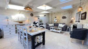 a kitchen and living room with a table and chairs at Charmante villa dans le centre village in Ars-en-Ré