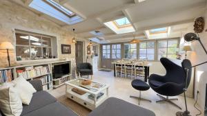 a living room with a couch and chairs and a table at Charmante villa dans le centre village in Ars-en-Ré