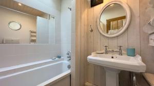 a bathroom with a sink and a mirror and a tub at Charmante villa dans le centre village in Ars-en-Ré +8 photos