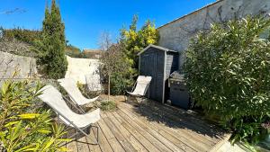 a deck with two chairs and a grill on it at Charmante villa dans le centre village in Ars-en-Ré