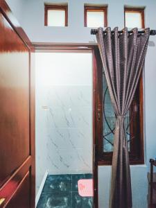 una puerta con una cortina en una habitación en Palma Villa Homestay Klaten, en Kuwoso