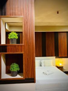 a bedroom with a bed with two potted plants at Hillcrest Boutique Hotel, Reddoors Canley Residential in Manila