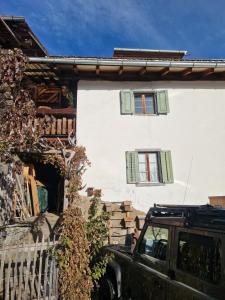 un coche aparcado frente a un edificio con dos ventanas en Patrizer Haus in Bergbauerndorf, en Cazis