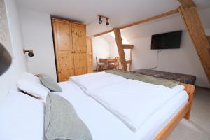 two beds in a room with a television and a table at SB-"PENSION Berggasse" - Gemeinschaftsküche, WIFI, Smart-TV, Zentral! in Olbernhau
