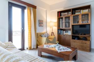 a living room with a couch and a tv at Villa Thalia in Gouves