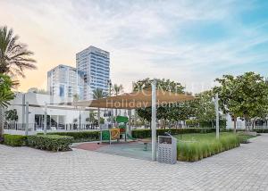 ein Park mit Sonnenschirm und Spielplatz in der Unterkunft Bloomfields 2BR Villa Beach Access Fujairah in Fudschaira