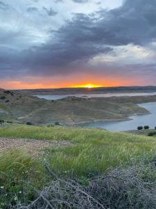 a sunset over a body of water in a field at Villa HMR ⵥ in Rhorm el Alem