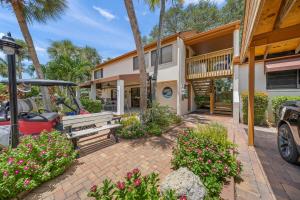 a building with a bench and flowers in front of it at Midnight Cove II 111F in Siesta Key