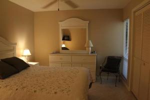 a bedroom with a bed and a dresser and a mirror at Midnight Cove II 117F in Siesta Key