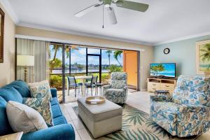 a living room with a blue couch and chairs at Midnight Cove II 111F in Siesta Key