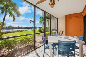 a dining room with a table and chairs and a view of the water at Midnight Cove II 111F in Siesta Key