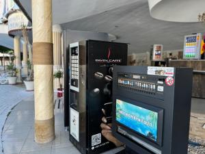 a person is standing next to a pay phone vending machine at TEA Prizren Hotel in Prizren