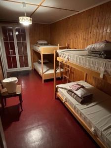 a room with two bunk beds and a red floor at Swiss Horizon-Gruppenhaus Mullern, vielseitiges Haus für Familien, Gruppen, Seminare und Gemeinschaft in Mollis