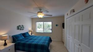 a bedroom with a blue bed and a ceiling fan at Midnight Cove II 128F in Siesta Key +41 photos