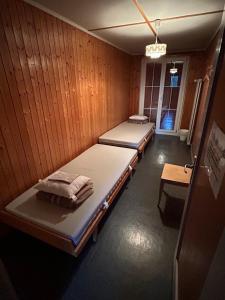 a room with two beds in a wooden wall at Swiss Horizon-Gruppenhaus Mullern, vielseitiges Haus für Familien, Gruppen, Seminare und Gemeinschaft in Mollis