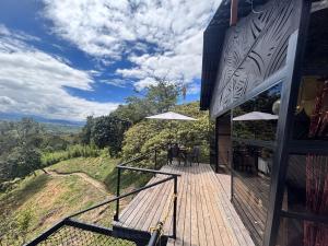 un ponte di legno con tavoli e ombrelloni su una collina di Luna Creciente Refugio de Luz y Naturaleza a Silvania
