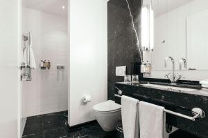 a black and white bathroom with a toilet and a sink at Hotel Borg by Keahotels in Reykjavík