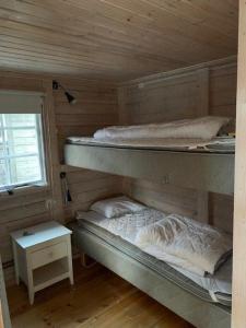 two bunk beds in a wooden cabin with a window at Stunning Home In Lärbro With One Bedroom in Kappelshamn
